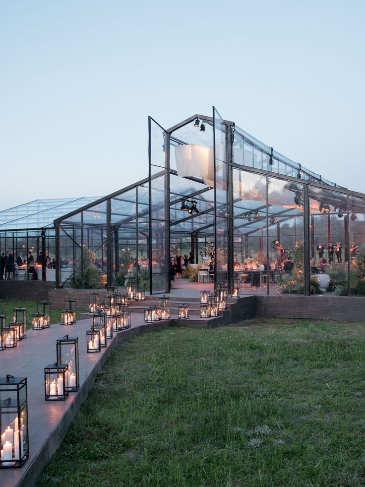 many candles are lit in front of a glass house