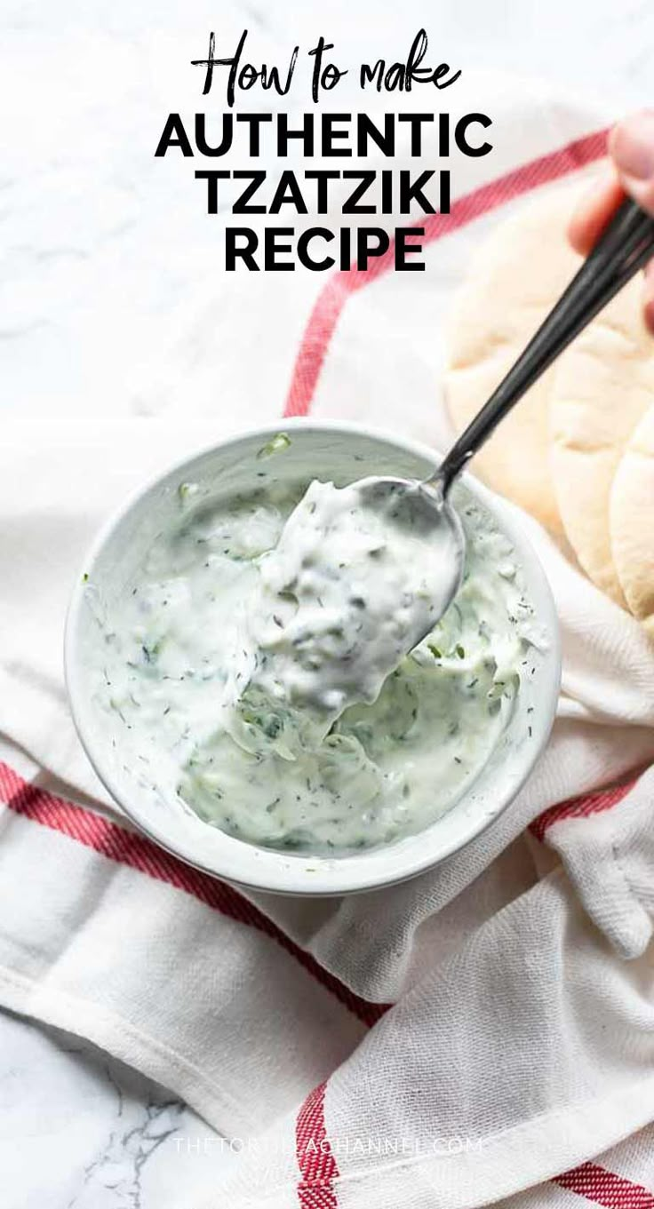 a white bowl filled with tzatzki sauce on top of a red and white towel