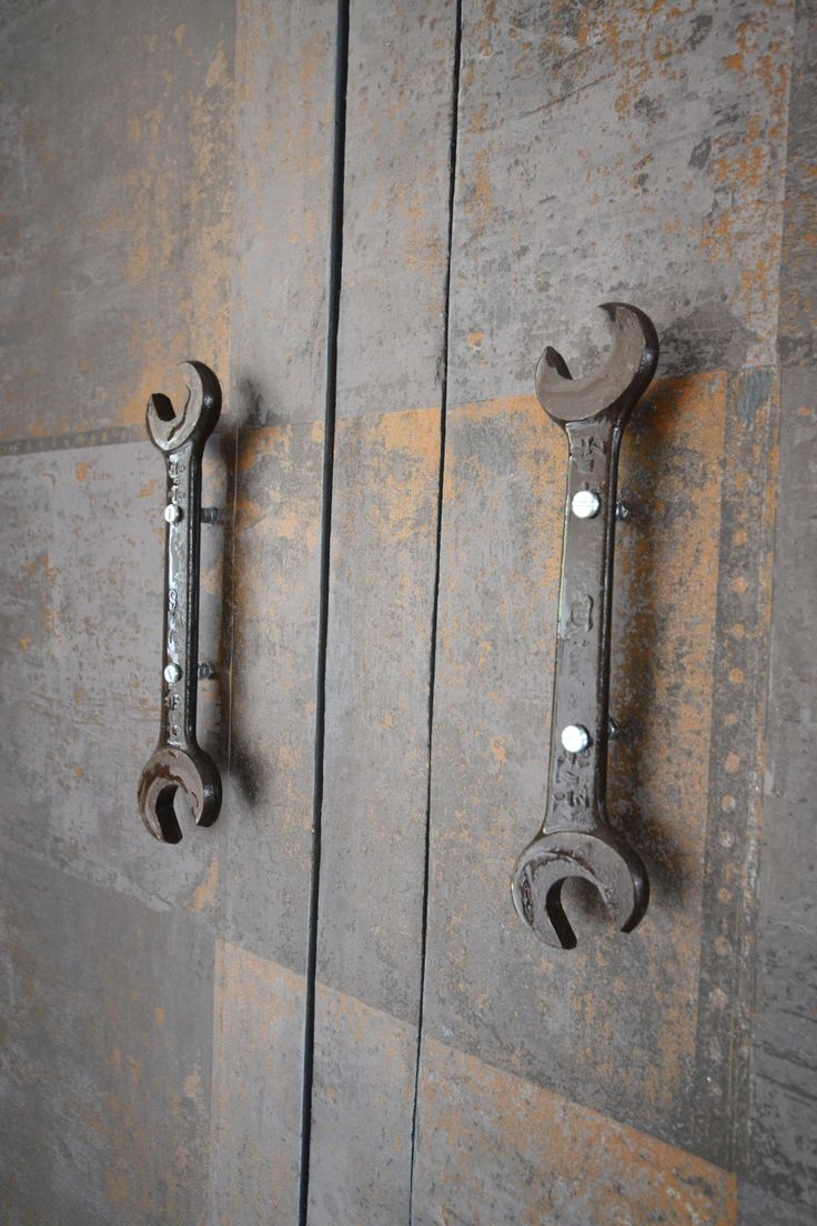 two metal latches are attached to the side of a door with rivets