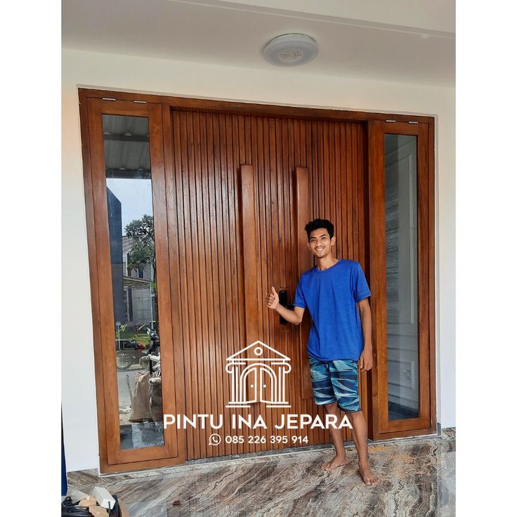 a young boy standing in front of a wooden door with the words pintu ina jepara on it