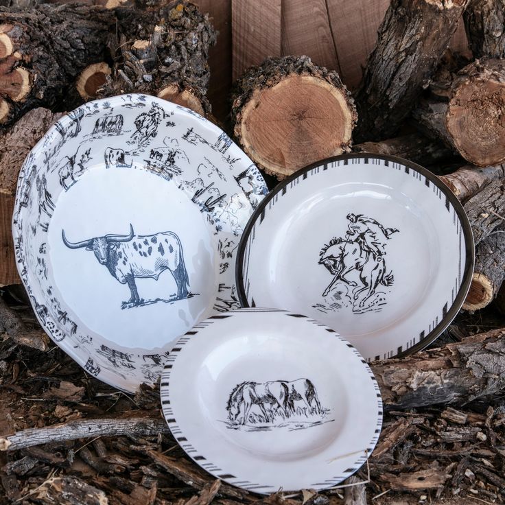 three plates with designs on them sitting in front of some wood slices and logs,