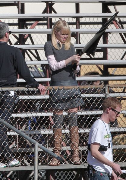 a woman standing next to a man in front of a crowd on top of a bleachers