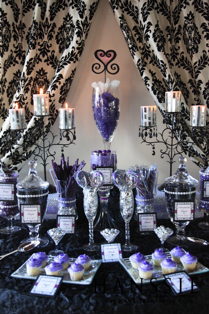 a table topped with cupcakes and cakes covered in purple frosting