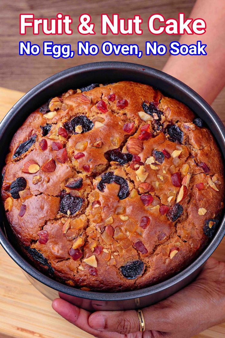 a person holding a fruit and nut cake