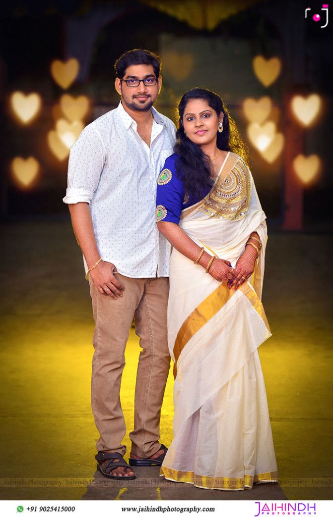 a man and woman standing next to each other in front of heart - shaped lights