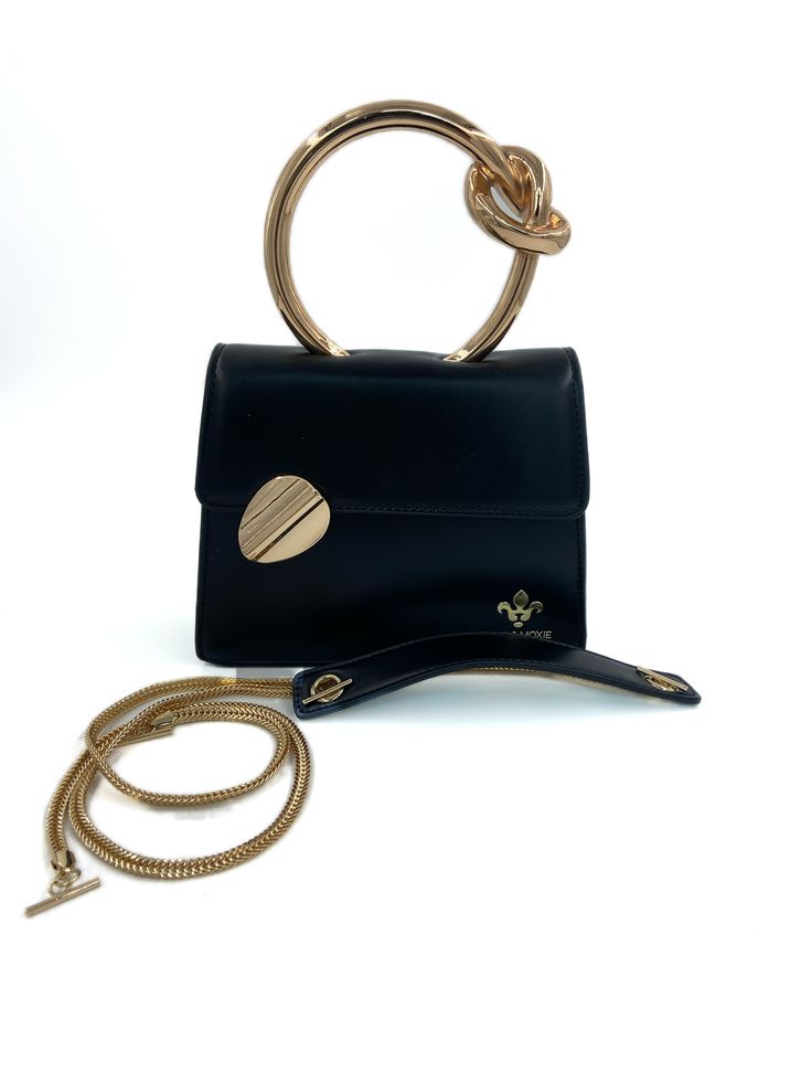 Gold circular handle structured handbag with detachable crossbody chain. Elegant Satchel With Metal Hardware And Round Handle, Chic Clutch With Detachable Strap, Chic Evening Bag With Detachable Double Handle, Gold Shoulder Bag With Metal Hardware And Round Handle, Chic Evening Bag With Gold-tone Hardware And Double Handle, Gold Shoulder Bag With Round Handle And Metal Hardware, Chic Gold Shoulder Bag With Round Handle, Modern Crossbody Box Bag With Chain Strap, Chic Shoulder Bag With Adjustable Round Handle