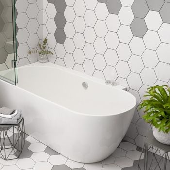 a white bath tub sitting next to a green plant