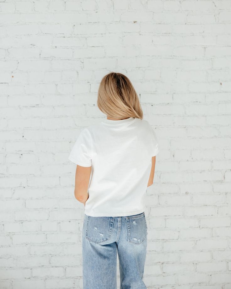 If you’re like all of us and have been looking for THE. PERFECT. TEE……. IT’S HEREEE!!! This white tee is not see through, yet is lightweight, classy and will go with everything. It’s the perfect cropped length that can be tucked in or left out. When we say you need this tee, YOU NEED THIS TEE! True to size being slightly cropped and oversized. ﻿Styled With: ﻿90's High Rise Straight Jeans Model Info: Makena is 5’6 wearing size Small. Simple White Tops With Graphic Print, White Casual Basic Tops, Basic White T-shirt For Spring, Casual White Everyday Tops, White Basic Crew Neck Top, White Basic Style T-shirt For Spring, White Casual Cropped T-shirt For Everyday, White Cropped T-shirt For Everyday Summer Wear, Trendy White Cropped T-shirt For Everyday