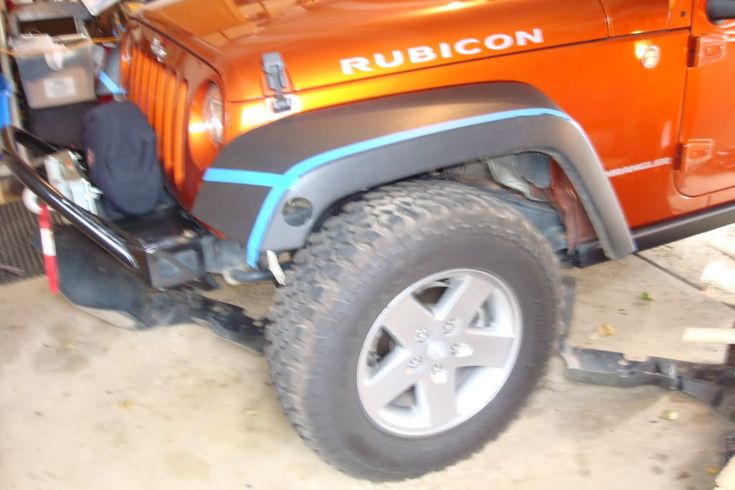 an orange jeep is parked in a garage