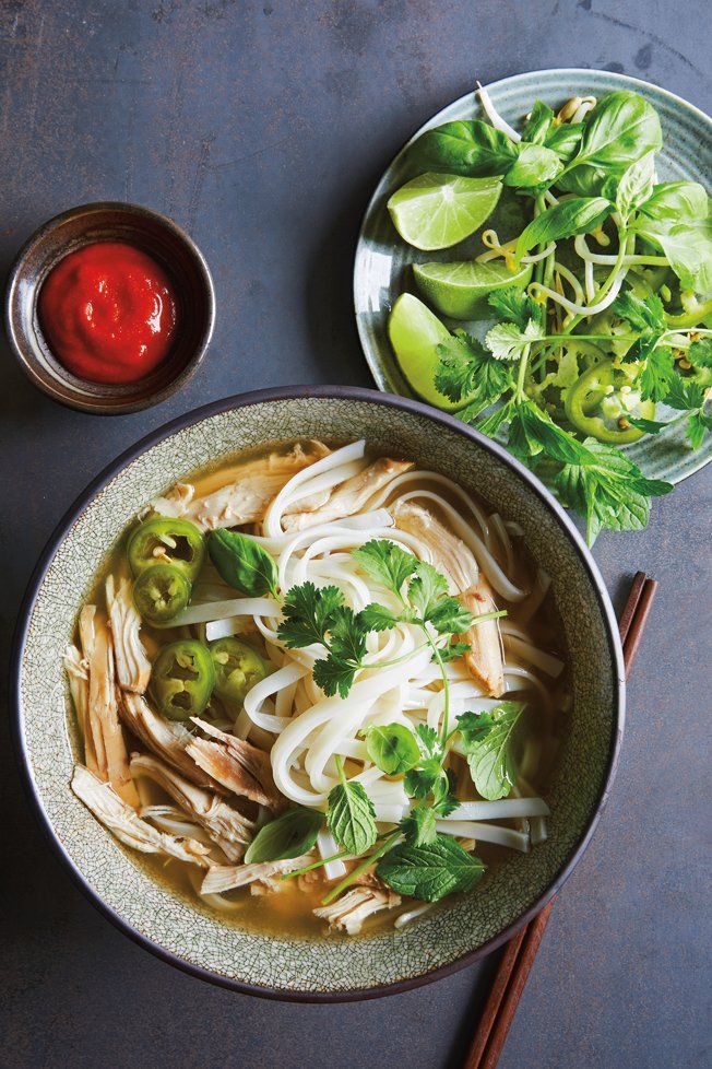 two bowls filled with noodles and vegetables next to some chopsticks on a table