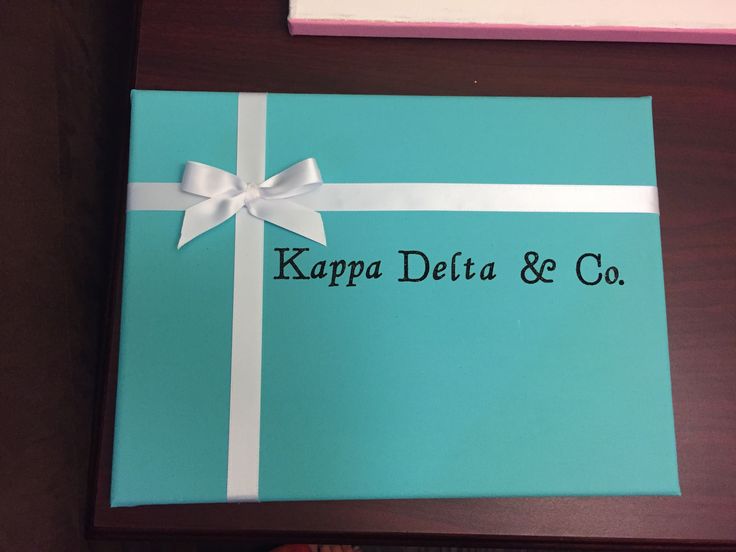 a blue gift box with a white ribbon and the words kappa delta & co on it