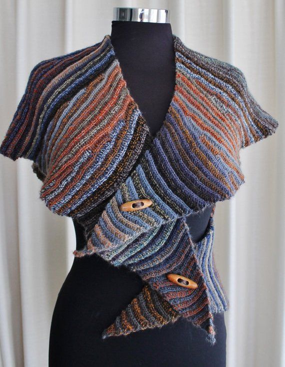 a close up of a mannequin wearing a knitted shawl with buttons on it