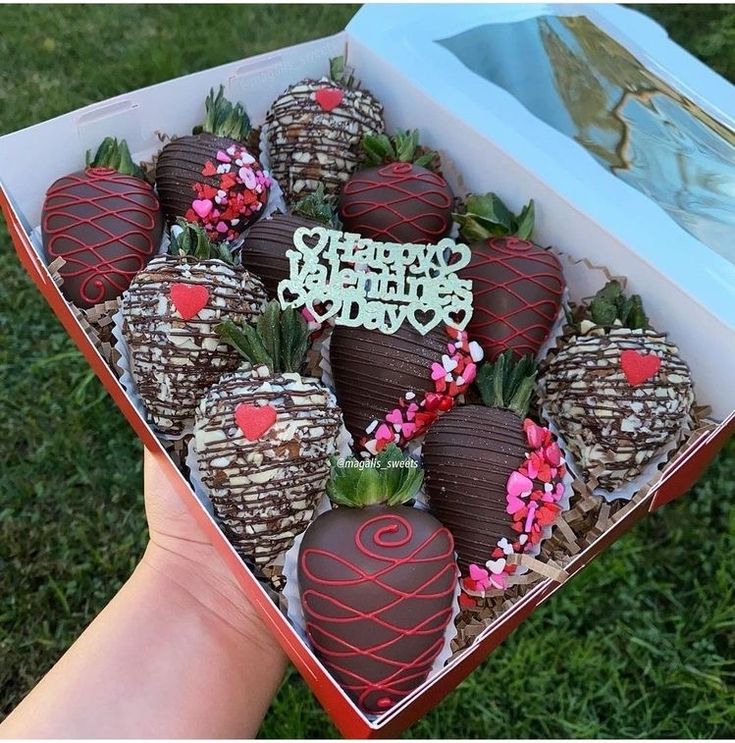 chocolate covered strawberries are in a box on the grass