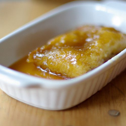 a small white dish filled with food on top of a wooden table