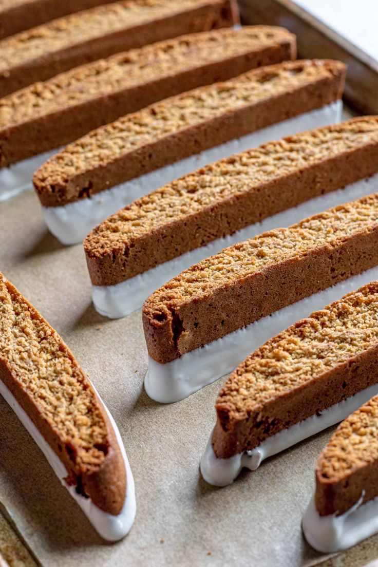 several slices of cake sitting on top of a baking pan covered in white icing