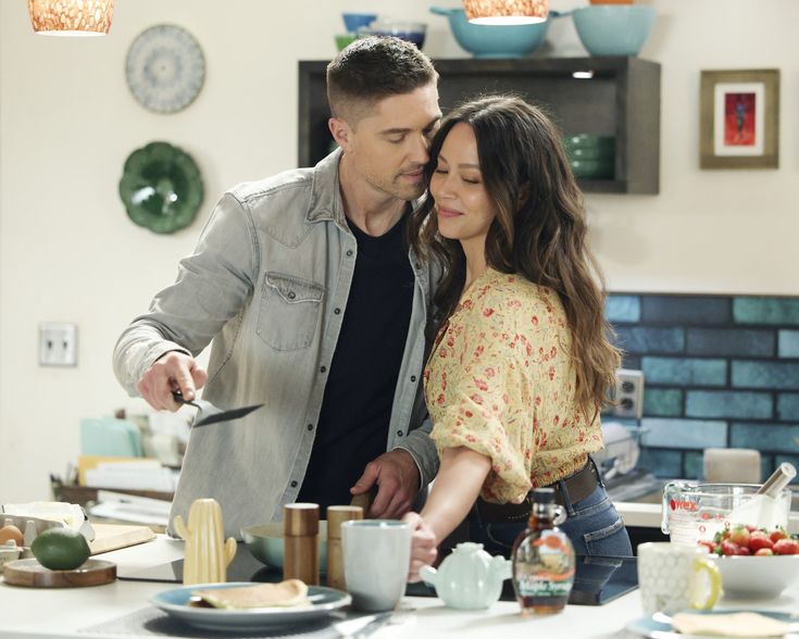 a man and woman in the kitchen preparing food