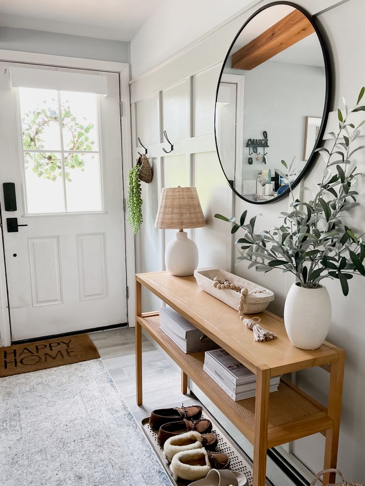 a wooden table topped with shoes next to a mirror and plant in front of a door