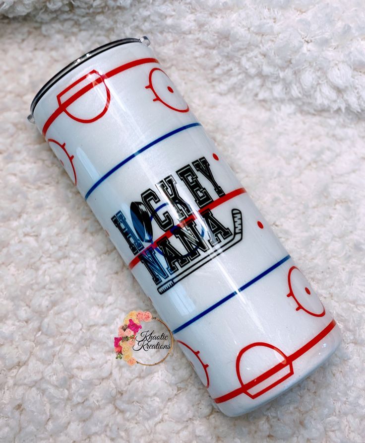 a close up of a can on a white surface with a teddy bear in the background