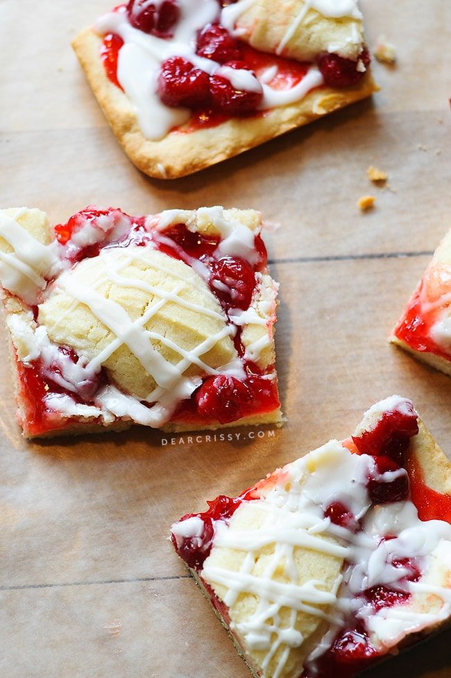 strawberry shortcakes with whipped cream on them are sitting on a piece of parchment paper