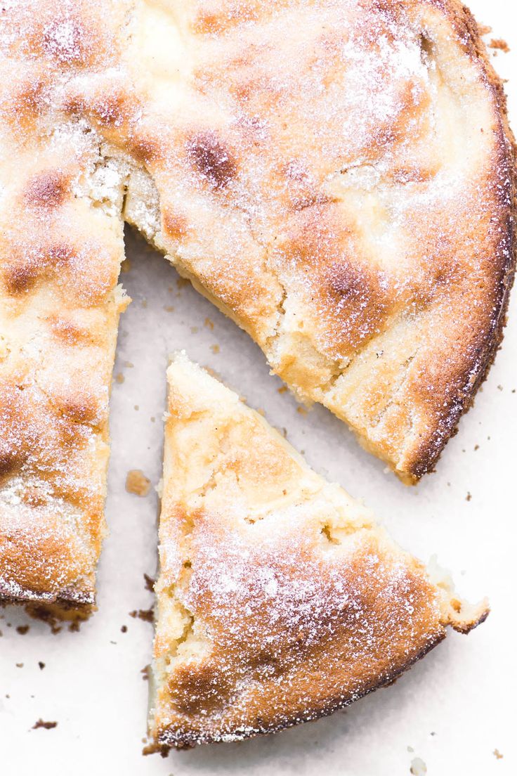 a close up of a pie with one slice cut out and powdered sugar on top