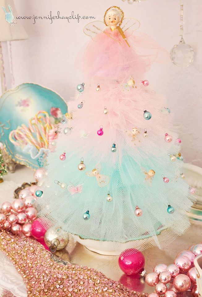 a colorful christmas tree is surrounded by other ornaments and decorating items in pink, blue, and green colors