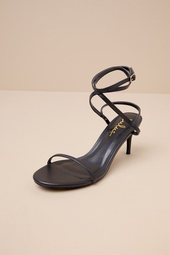 The sexy vibes of the beloved Lulus Sydd Ankle Wrap High Heel Sandals just got a comfy upgradeâ€”the Lulus Sydd Black Ankle Wrap Low Heel Sandals! Smooth faux leather shapes these must-have heels that feature a single sole silhouette with an almond-shaped footbed and a slender toe strap. Matching straps sprout from the sides to wrap and secure around the ankle with a gold buckle, all atop a low, stiletto-style heel! 2. 75" Stiletto heel. Lightly cushioned insole. Rubber sole has nonskid markings Adjustable Strappy Heels For A Night Out, Chic Sandals With Ankle Strap For Night Out, Chic Ankle Strap Sandals For Night Out, Adjustable Strappy Heels For Night Out, Chic Strappy Sandals For Date Night, Chic Adjustable Strappy Heels, Spring Ankle Wrap Sandals For Night Out, Chic Adjustable High Heel Sandals, Summer Night Out Ankle Wrap Sandals