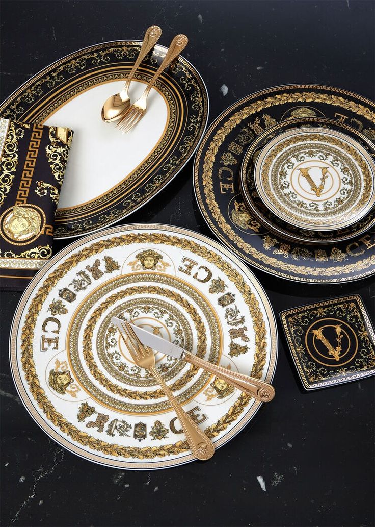 four plates with gold and black designs on them