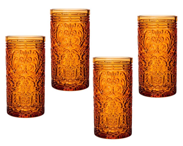 four orange glass tumblers sitting next to each other on a gray surface with an intricate design