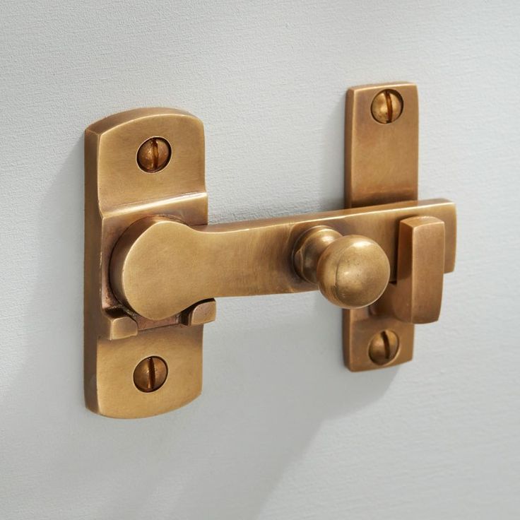 a close up of a door handle on a white wall with gold colored knobs