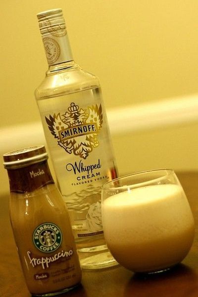 an assortment of drinks sitting on top of a wooden table next to a glass filled with liquid