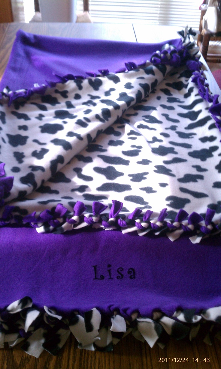 a purple and white blanket on top of a table with the name lisa written on it