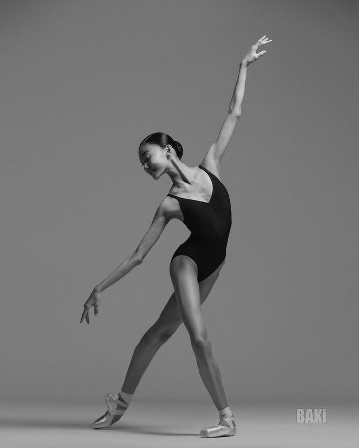 a woman in a black leotard and ballet shoes