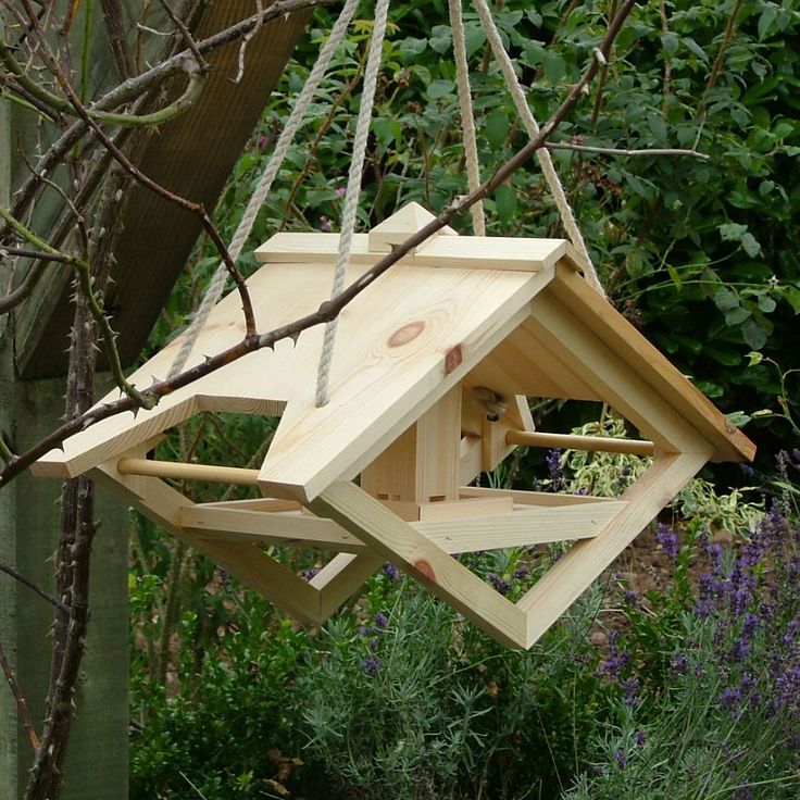 a wooden bird house hanging from a tree