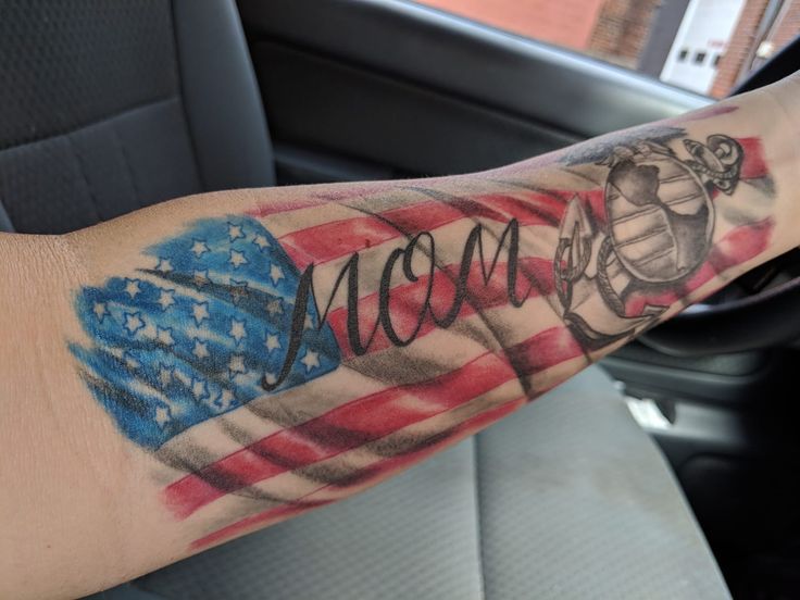 a man's arm with an american flag and the word moon tattooed on it