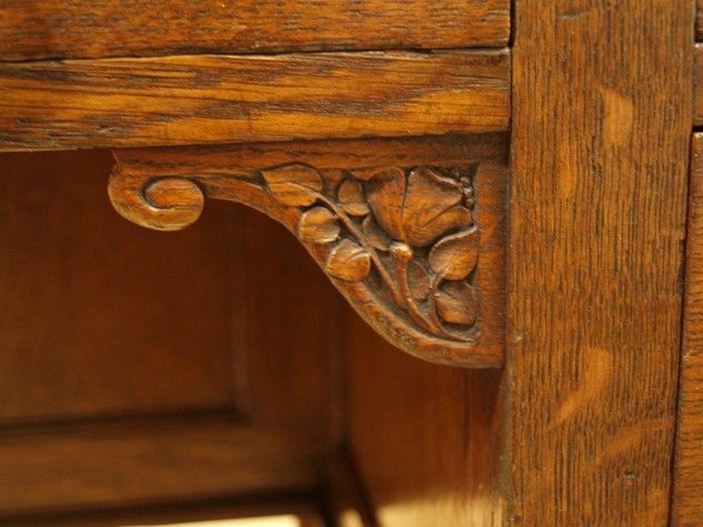 an old wooden table with carvings on the top and bottom drawer, close - up