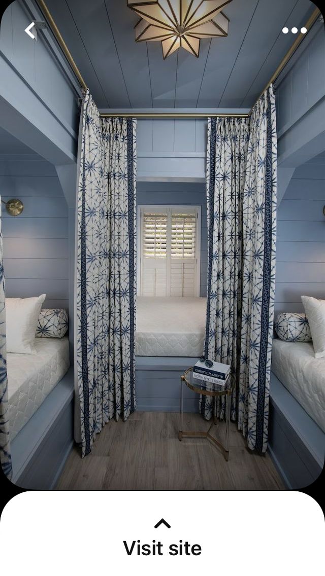 a room with two beds and curtains in it