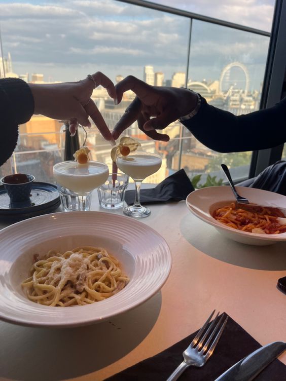 two people sitting at a table with plates of food