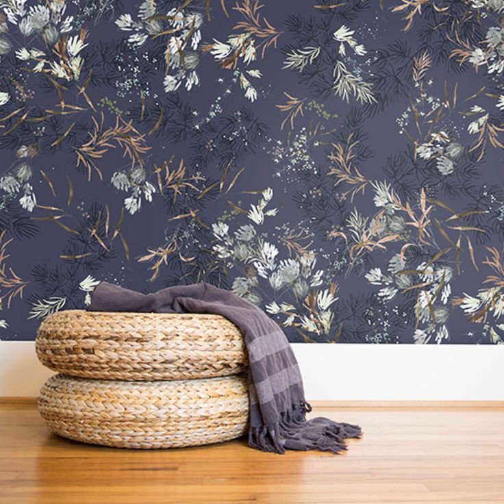 a basket sitting on top of a wooden floor next to a wallpapered wall