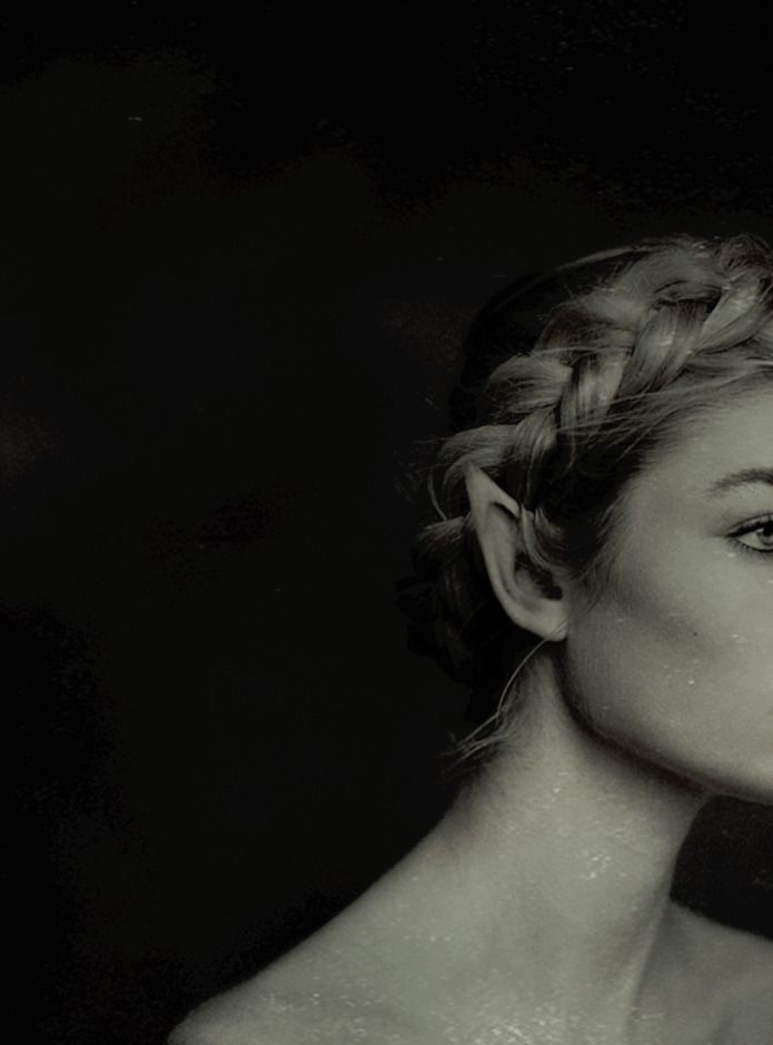 a black and white photo of a woman with braids in her hair looking off to the side