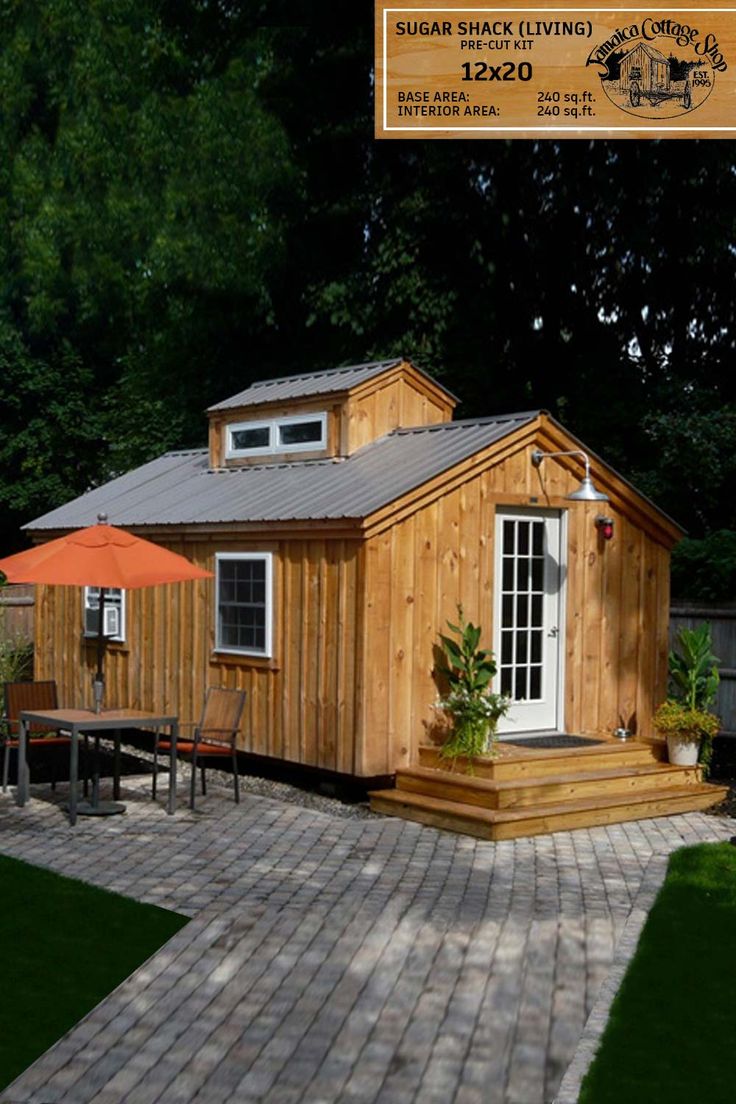 a small wooden house with an umbrella on the patio