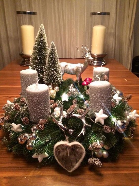 a christmas centerpiece with candles and ornaments