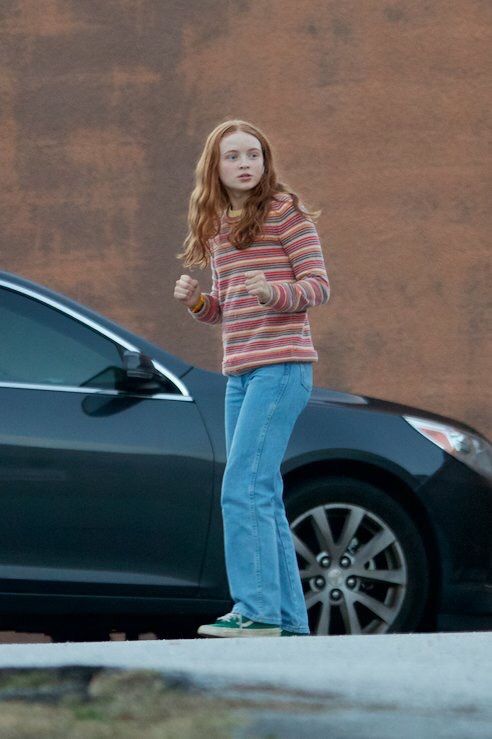 a woman standing next to a car with the caption'strange things season 2 sadie is mad max