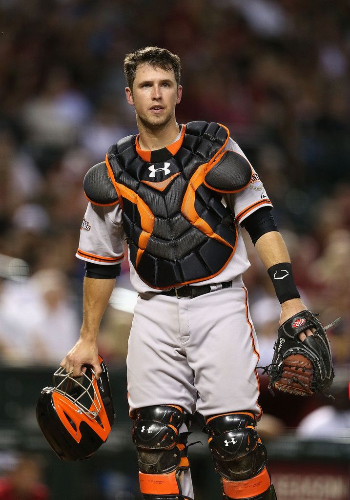 a baseball player holding catchers mitts and gloves