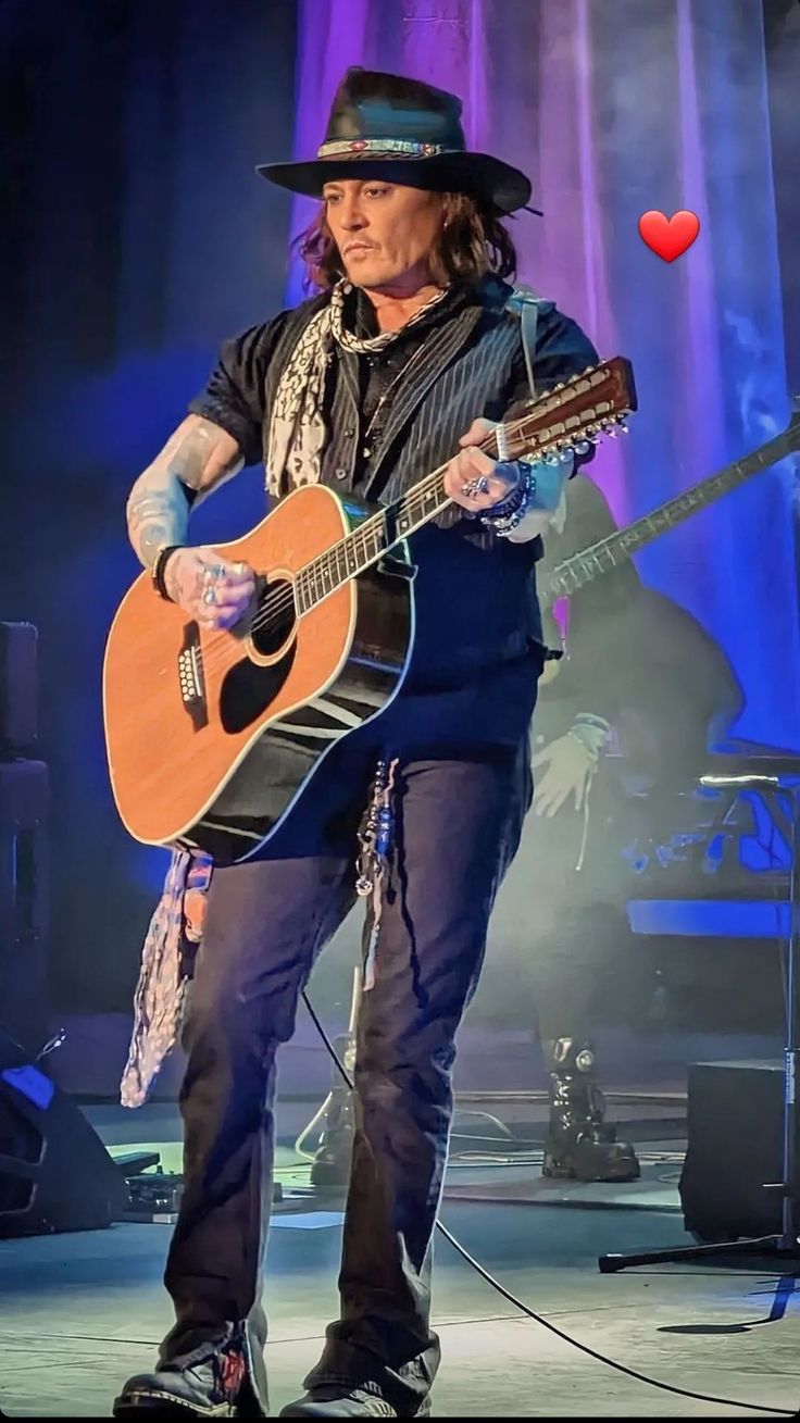 the man is playing his guitar on stage