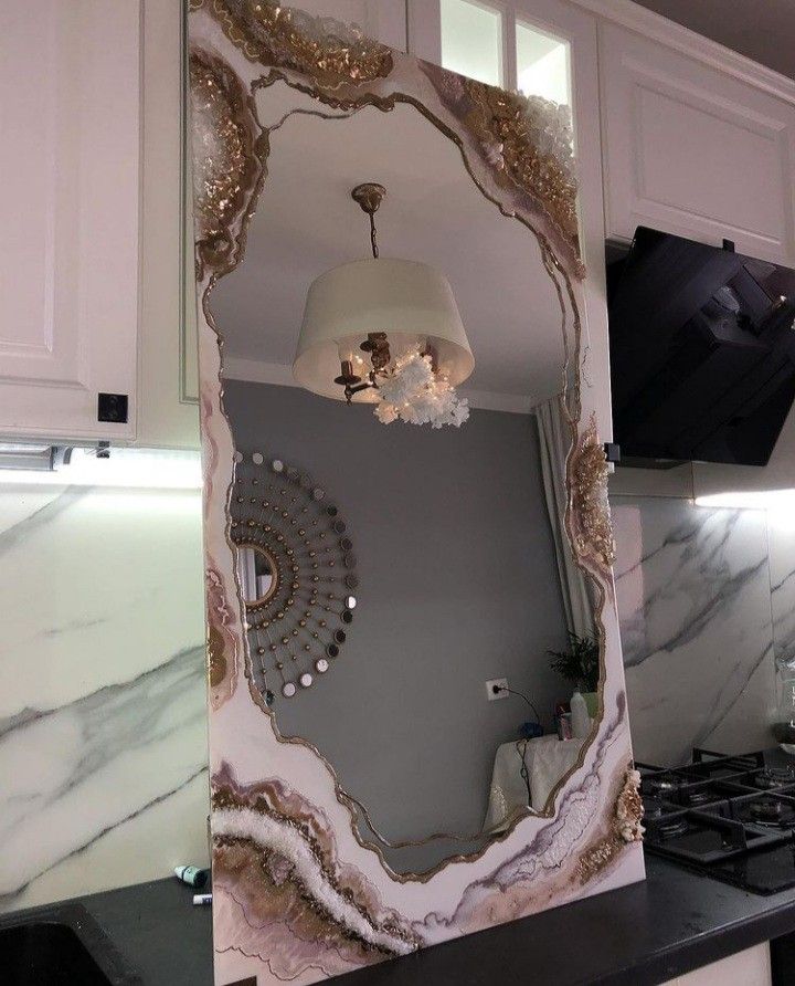 a mirror that is on the side of a wall above a stove top in a kitchen