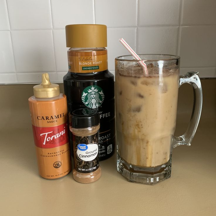 there is a cup of iced coffee next to some condiments on the counter