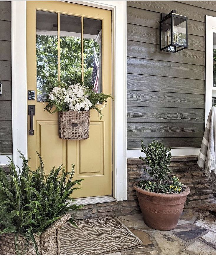 a yellow door and some plants on the front porch