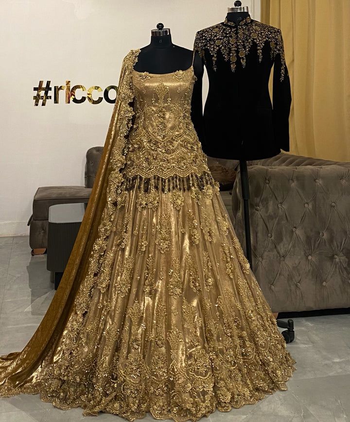 two mannequins are dressed in gold and black gowns, one is on display