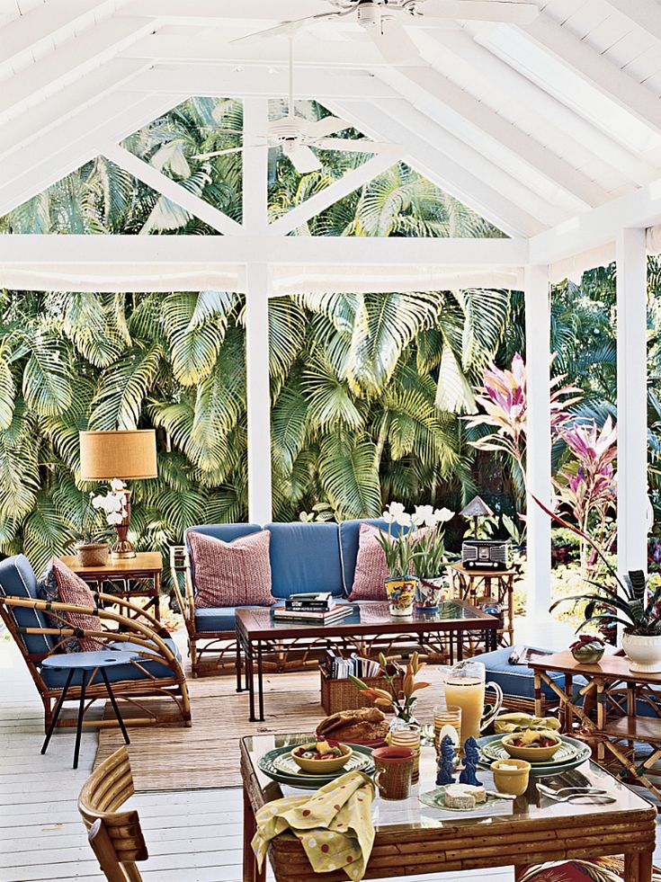 a covered patio with furniture and plants in the background