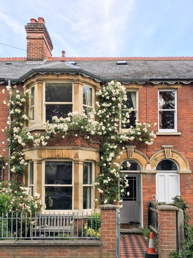 a brick building with white flowers growing on it